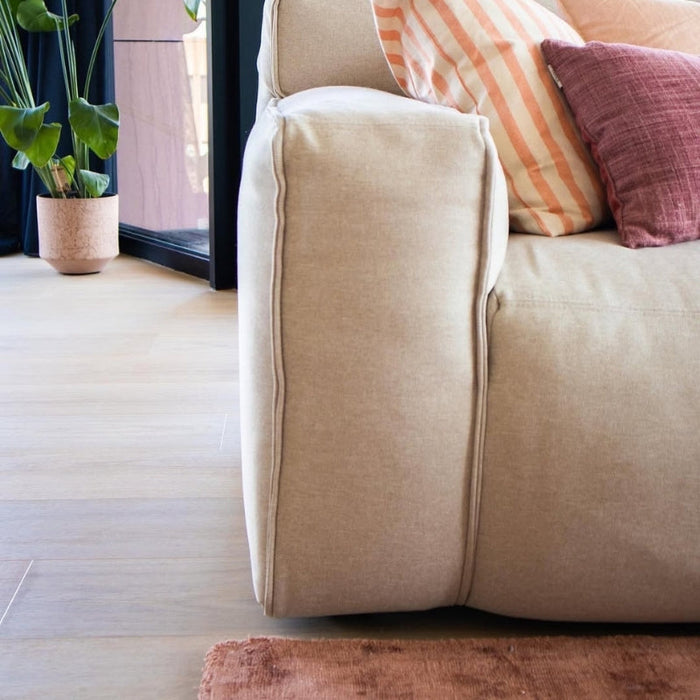 Vivafloors 7810 click pvc vloer met rechte planken in woonkamer met beige bank en roze accenten.